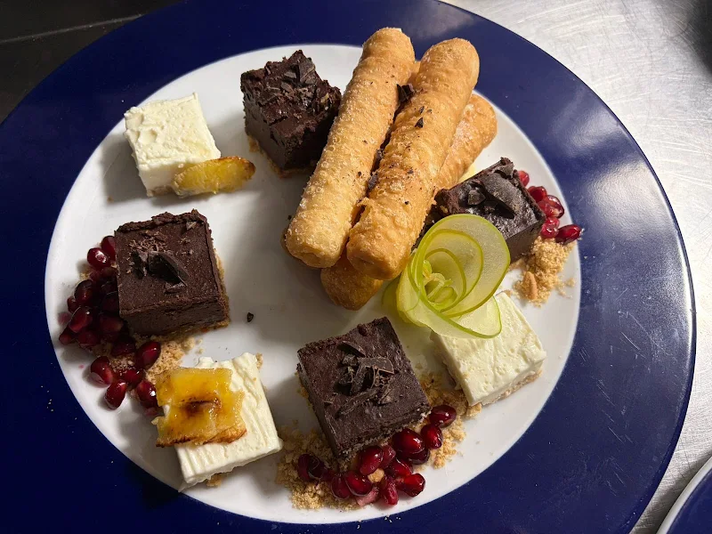 Surtido de postres: chocolate, tarta de queso y masa frita, con granada
